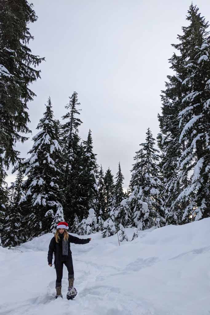 Snowshoeing in Vancouver, Amy surrounded by white snow and tall trees